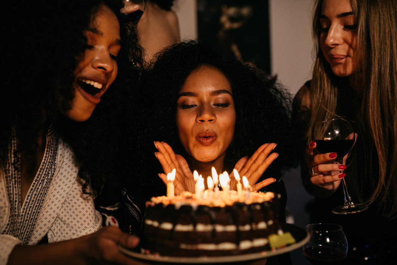 Woman Blowing Birthday Cake